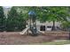 A fun playground with slides and climbing structures, surrounded by lush greenery and a secure fence at 3456 Sardis Bend Dr, Buford, GA 30519