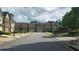 Street view of townhomes showing landscaping, sidewalks, and architectural details in a residential area at 3456 Sardis Bend Dr, Buford, GA 30519