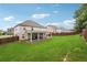 Spacious backyard featuring a patio, green grass, and wooden fence at 3670 Casual Ridge Way, Loganville, GA 30052