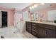 Bathroom featuring dual sinks, granite counters, bathtub, and white tile flooring at 3670 Casual Ridge Way, Loganville, GA 30052