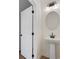 Powder room with pedestal sink, round mirror, and decorative lighting creating a cozy space at 401 Carrera Ln, Acworth, GA 30102