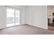 Bright living room with neutral carpet and sliding doors to a balcony with a black metal railing at 525 Parkway Dr # 218, Atlanta, GA 30354