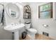Charming powder room with a pedestal sink, decorative mirror, and neutral decor, combining style and functionality at 5661 Fairwood Nw Dr, Acworth, GA 30101