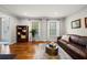 Cozy living room features hardwood floors, a leather sofa, and lots of natural light from the large windows at 5661 Fairwood Nw Dr, Acworth, GA 30101