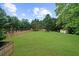 Backyard featuring a large grassy area enclosed by a wooden fence, perfect for pets and play at 7020 Walnut Mill Lndg, Cumming, GA 30040