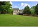 Expansive backyard with lush lawn, mature trees, and a wooden fence at 7020 Walnut Mill Lndg, Cumming, GA 30040