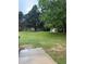 Spacious backyard with a patio and lush green lawn, bordered by mature trees at 7020 Walnut Mill Lndg, Cumming, GA 30040