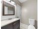 Bathroom featuring a vanity with a granite countertop, a modern mirror, and a white toilet at 7020 Walnut Mill Lndg, Cumming, GA 30040