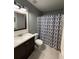 Bathroom featuring a vanity with dark cabinets and a gray and blue geometric shower curtain at 7020 Walnut Mill Lndg, Cumming, GA 30040