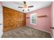 Bedroom with a ceiling fan, carpet, and a wooden accent wall at 7020 Walnut Mill Lndg, Cumming, GA 30040