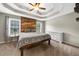 Bedroom featuring tray ceiling, wood accent wall, and dresser at 7020 Walnut Mill Lndg, Cumming, GA 30040