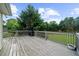 Wooden deck with gray railings and a grill overlooking lush landscaping and mature trees at 7020 Walnut Mill Lndg, Cumming, GA 30040