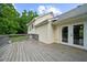 Back of house featuring a wooden deck overlooking green backyard with double doors for inside/outside entertaining at 7020 Walnut Mill Lndg, Cumming, GA 30040