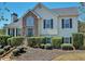 Charming two-story home featuring a stone facade, manicured landscaping, and a welcoming front entrance at 7020 Walnut Mill Lndg, Cumming, GA 30040