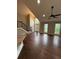 Open-concept living area with high ceilings, hardwood floors, large windows, and staircase at 7020 Walnut Mill Lndg, Cumming, GA 30040