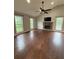 Cozy living room features a stone fireplace, hardwood floors, recessed lighting, and large windows at 7020 Walnut Mill Lndg, Cumming, GA 30040