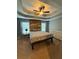 Comfortable bedroom with natural light, wood accent wall, tray ceiling, and carpeted floor at 7020 Walnut Mill Lndg, Cumming, GA 30040