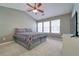 Bright bedroom featuring a large window, plush carpet, and a ceiling fan at 1207 Penhurst Way, Lawrenceville, GA 30043