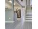 Open-concept living area and staircase featuring new gray flooring and a view into the kitchen at 1207 Penhurst Way, Lawrenceville, GA 30043
