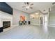 Spacious living room featuring a fireplace, a ceiling fan, and sleek gray flooring at 1207 Penhurst Way, Lawrenceville, GA 30043