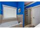 Bathroom featuring a tub, tiled walls, shower, and a bright blue accent wall at 230 Ryan Ln, Covington, GA 30014