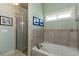 Bright bathroom featuring a tub, tiled walls, and glass door shower at 230 Ryan Ln, Covington, GA 30014