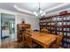 Elegant dining room featuring a wood table, chandelier, and a built-in bookshelf stocked with books and decorative items at 230 Ryan Ln, Covington, GA 30014
