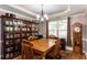 Elegant dining room with wood table, custom built-ins, chandelier, and natural light at 230 Ryan Ln, Covington, GA 30014