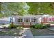 Charming blue house featuring a welcoming front porch with white railings, a green lawn, and mature trees at 230 Ryan Ln, Covington, GA 30014