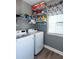 Functional laundry room with modern washer and dryer units and shelving for storage at 230 Ryan Ln, Covington, GA 30014