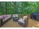 Outdoor deck features comfortable seating, a grill, and a serene view of the wooded backyard at 4410 Red Rock Pt, Suwanee, GA 30024