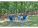 Cozy backyard fire pit area with Adirondack chairs and a gravel base for outdoor entertaining at 4410 Red Rock Pt, Suwanee, GA 30024
