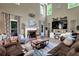 Comfortable living room with a fireplace, large windows, and cozy furniture at 4410 Red Rock Pt, Suwanee, GA 30024