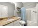 Bathroom with a marble countertop, floating shelves, and a shower with a decorative curtain at 931 Windsor Creek Dr, Grayson, GA 30017