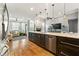 Open-concept kitchen with stainless steel appliances, hardwood floors, granite countertops, and views to the living room at 931 Windsor Creek Dr, Grayson, GA 30017