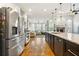 Open kitchen with stainless steel appliances, granite countertops, hardwood floors, and views into the adjacent living space at 931 Windsor Creek Dr, Grayson, GA 30017