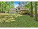 View of home's spacious backyard featuring deck and lush green scenery at 4181 Singing Post Ne Ln, Roswell, GA 30075