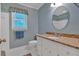 This cozy bathroom features a granite countertop, oval mirror, and blue walls at 4181 Singing Post Ne Ln, Roswell, GA 30075