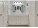 Bathroom featuring double sinks with quartz countertops, oval mirrors, and modern lighting fixtures at 4181 Singing Post Ne Ln, Roswell, GA 30075