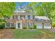 Charming brick two-story home with blue shutters and a well-manicured lawn, surrounded by mature trees at 4181 Singing Post Ne Ln, Roswell, GA 30075