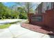 A welcoming brick sign marks the entrance to Mountain View Villages, a residential community surrounded by lush greenery and a sidewalk at 4966 Villager Ln, Stone Mountain, GA 30083