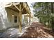 The back of a home with a wood deck and gravel with trees in the background at 4966 Villager Ln, Stone Mountain, GA 30083
