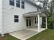This backyard features a covered patio with white columns and a gray concrete pad perfect for entertaining and relaxing at 93 Riverwood Dr, Dallas, GA 30157