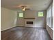Spacious living area with a fireplace, ceiling fan, and large windows bringing in natural light at 93 Riverwood Dr, Dallas, GA 30157