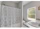 Clean bathroom featuring a shower with a curtain, neutral decor, and a bright window at 119 Sourwood Lane, Temple, GA 30179