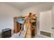 View of carpeted bedroom with lofted bed and storage beneath, accompanied by a dark wooden nightstand at 119 Sourwood Lane, Temple, GA 30179