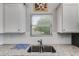Kitchen featuring granite countertops, stainless steel sink, and ample natural light at 119 Sourwood Lane, Temple, GA 30179