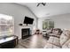 Cozy living room with fireplace, vaulted ceilings, wood floors, and large windows at 119 Sourwood Lane, Temple, GA 30179