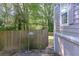 A wooden backyard fence with a gate and security sign, offers privacy to the home at 1390 Almont Sw Dr, Atlanta, GA 30310