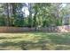 Large, grassy backyard is surrounded by a tall wooden fence and mature trees at 1390 Almont Sw Dr, Atlanta, GA 30310